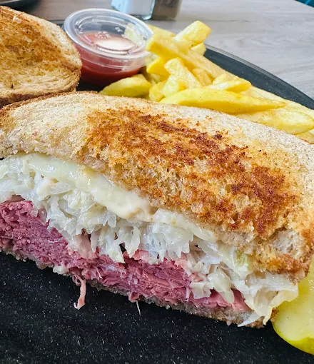 Toasted corned beef sandwich with sauerkraut, served with fries